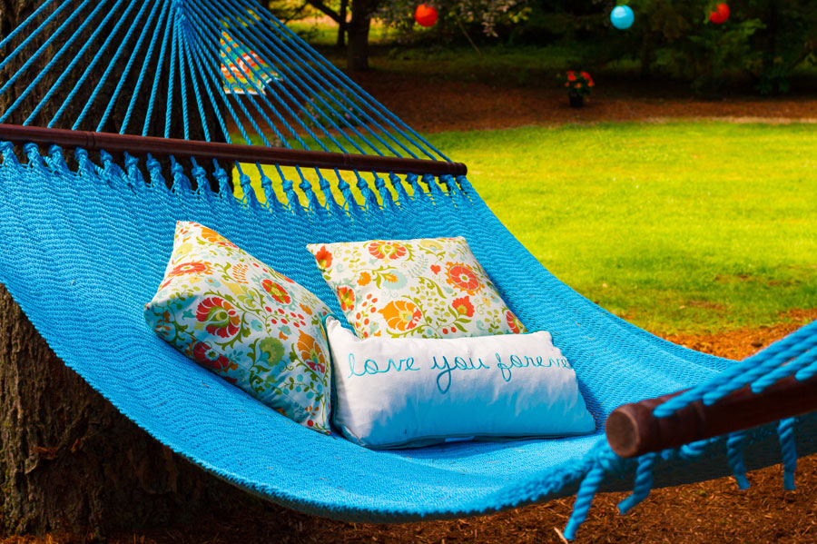 Blue hammock with homemade pillows with floral pattern and the wording "love you forever"