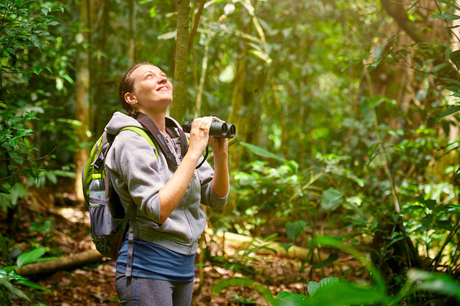 Women holding binoculars in the great outdoors enjoying nature and the wildlife