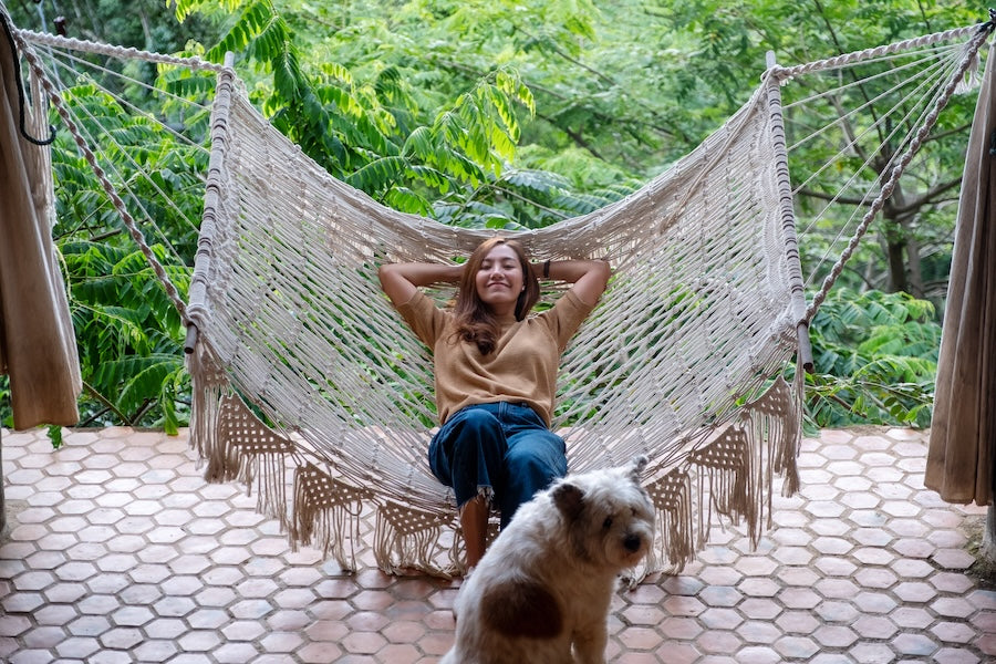 a women relaxing in her hammock on the patio, forrest backgrounf