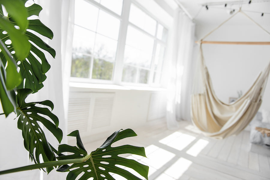 A hanging chair hammock in a well lit modern living room.