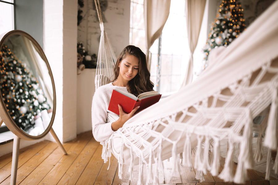 Beautiful women reading a book while sitting in a hammock.