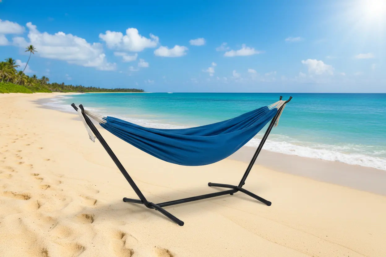 Blue hammock on a stand on a sandy beach with ocean and sky in the background