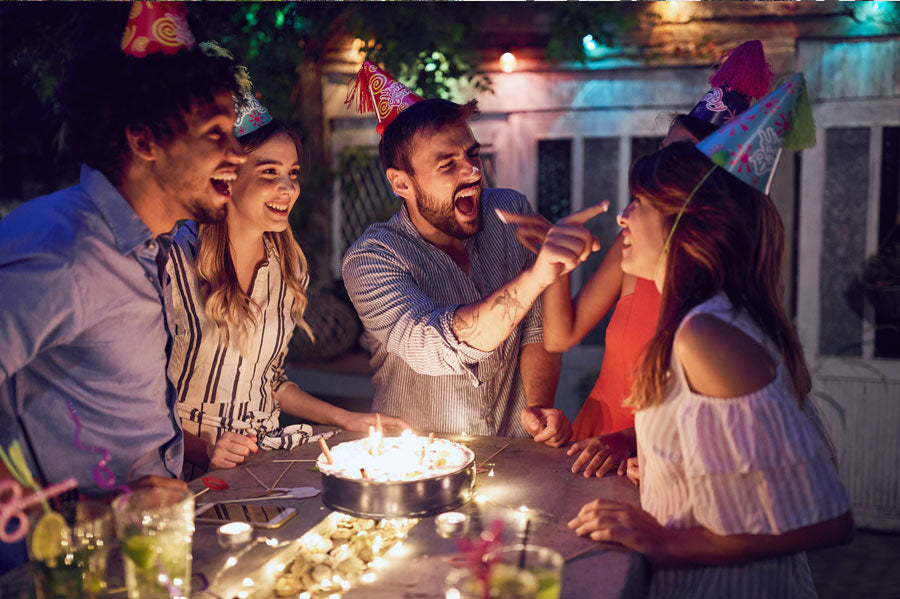 Group of friends celebrating a birthday and having fun at night