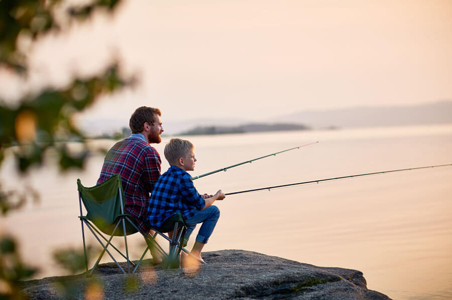 Father and Son enjoying the great outdoors and and fishing by the water