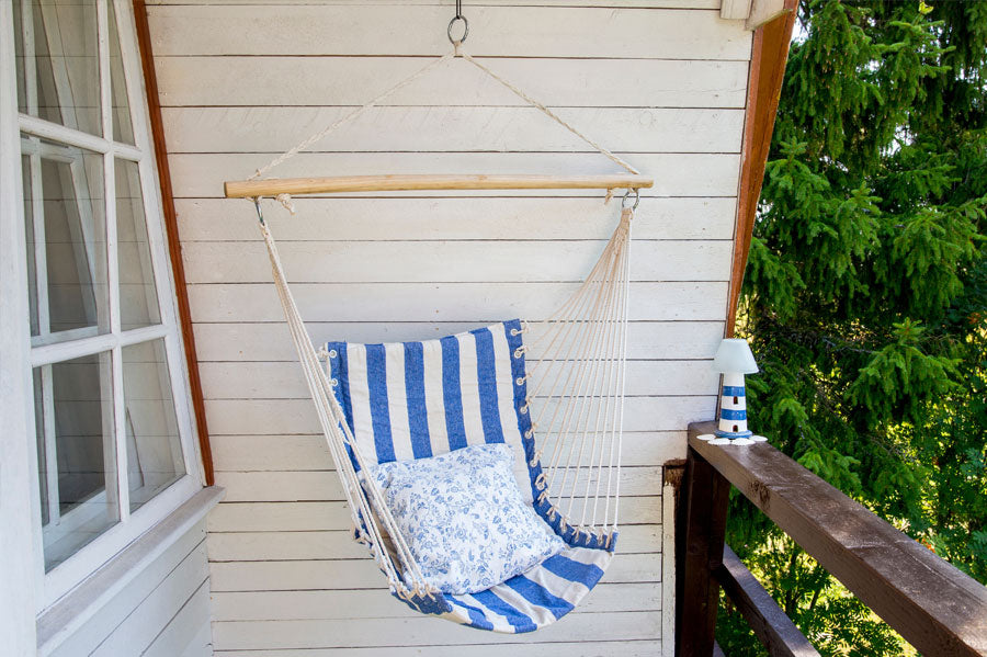 A hanging hammock chair on a porch.