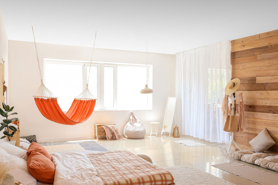A hammock hanging from the ceiling of a modern bedroom.