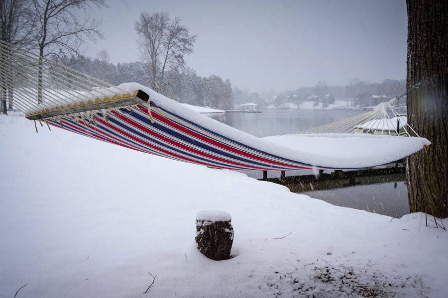 A hammock covered in snow, surrounded by a snowy landscape.