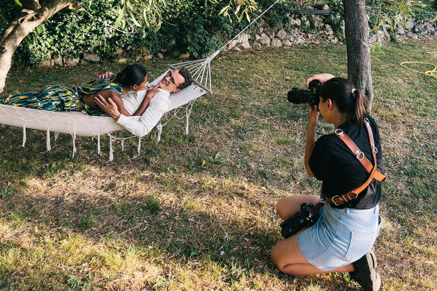 Women taking a photo of a couple relaxing on a hammock