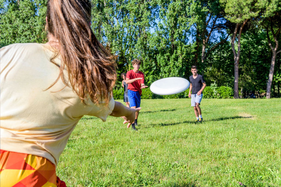 Group of friends playing frisbee in their backyard