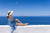 Women sitting on the white wall watching over the mediterranean sea in Greece