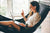 Smiling women working on her laptop in an indoor hammock