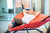 man with laptop holding hands behind head, relaxing and dreaming while lying on a hammock in office
