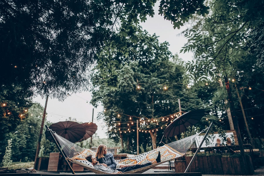 A couple in a hammock in the large backyard.