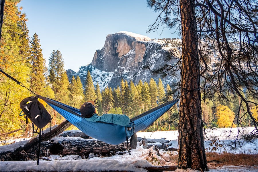 Man in a hammock enjoying the picturesque winter landscape of Half-dome, Yosemite national park