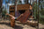 a person in a hammock relaxing, an eco-friendly small home in the backround. forrest setting