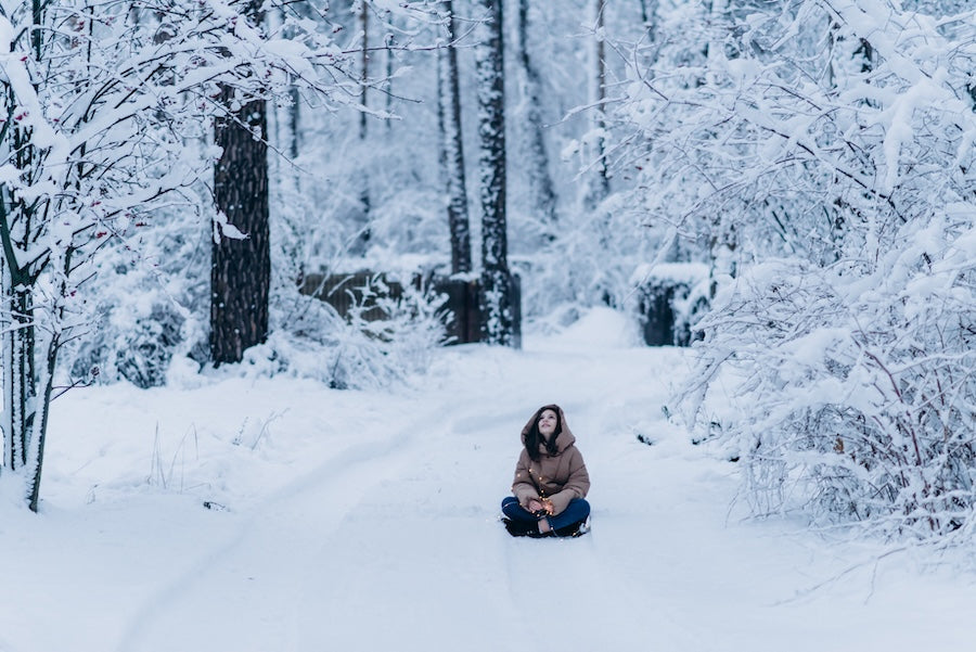 Beautiful young teenager woman in winter outdoor on a snowy street with lights garland in her hands