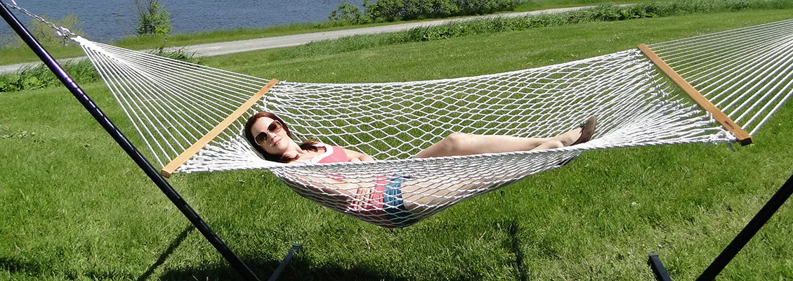 woman in a rope hammock on a tri-beam stand