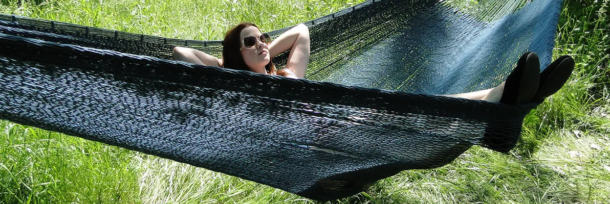 Woman in an XL forest green mayan hammock
