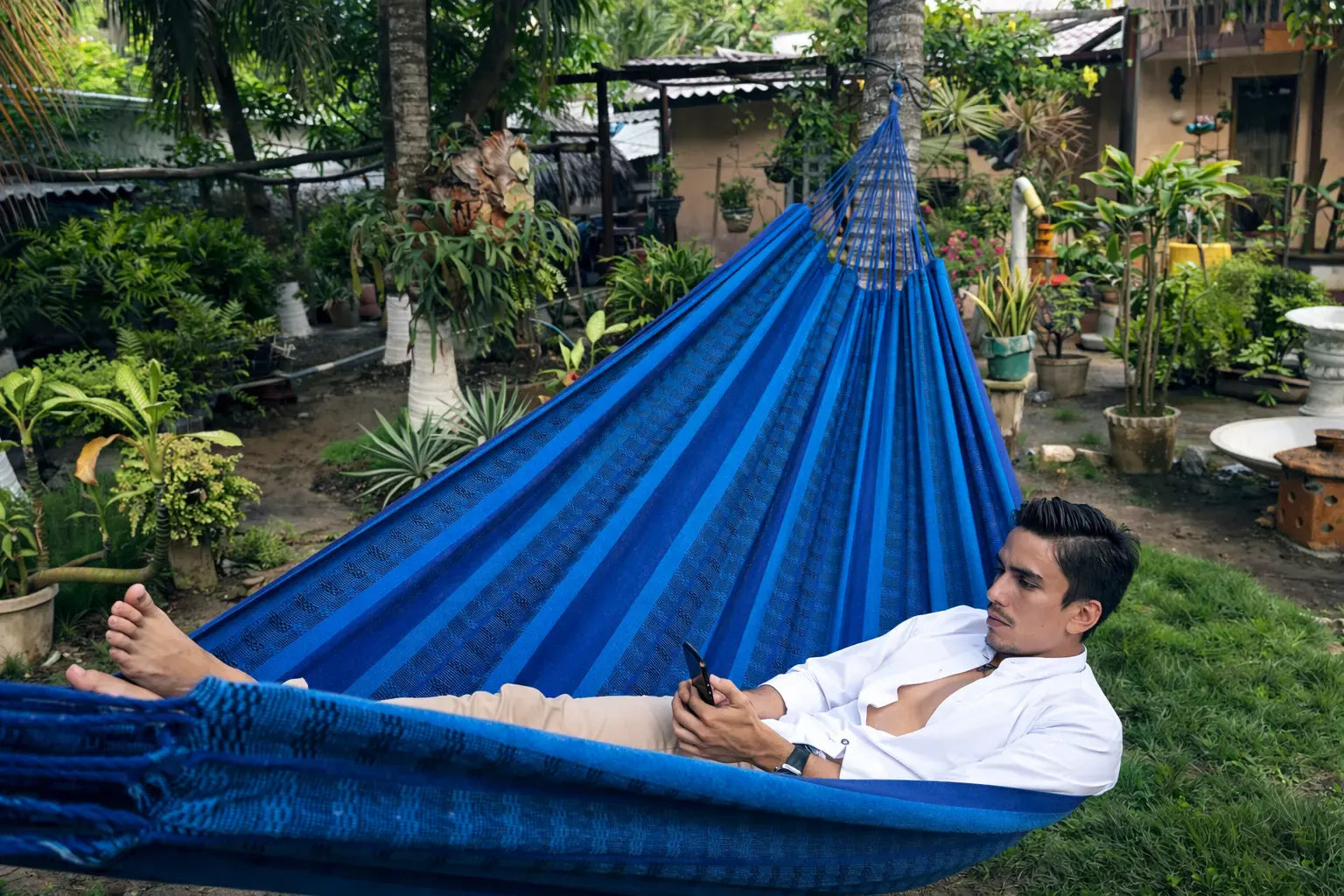 Person relaxing in a blue hammock in a garden setting 20190
