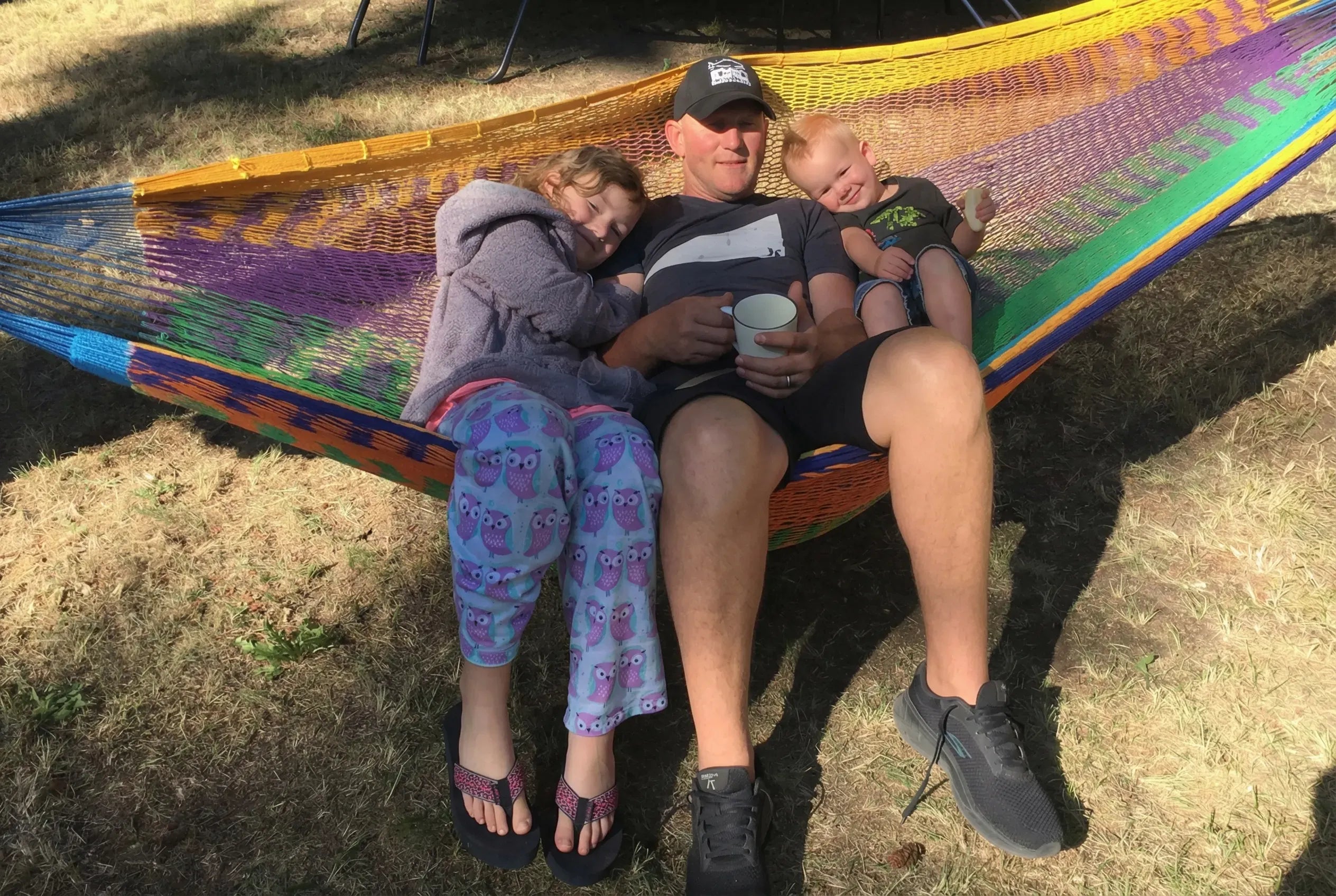 Man with two children in a colorful hammock on grass #24-MHXLTC-H