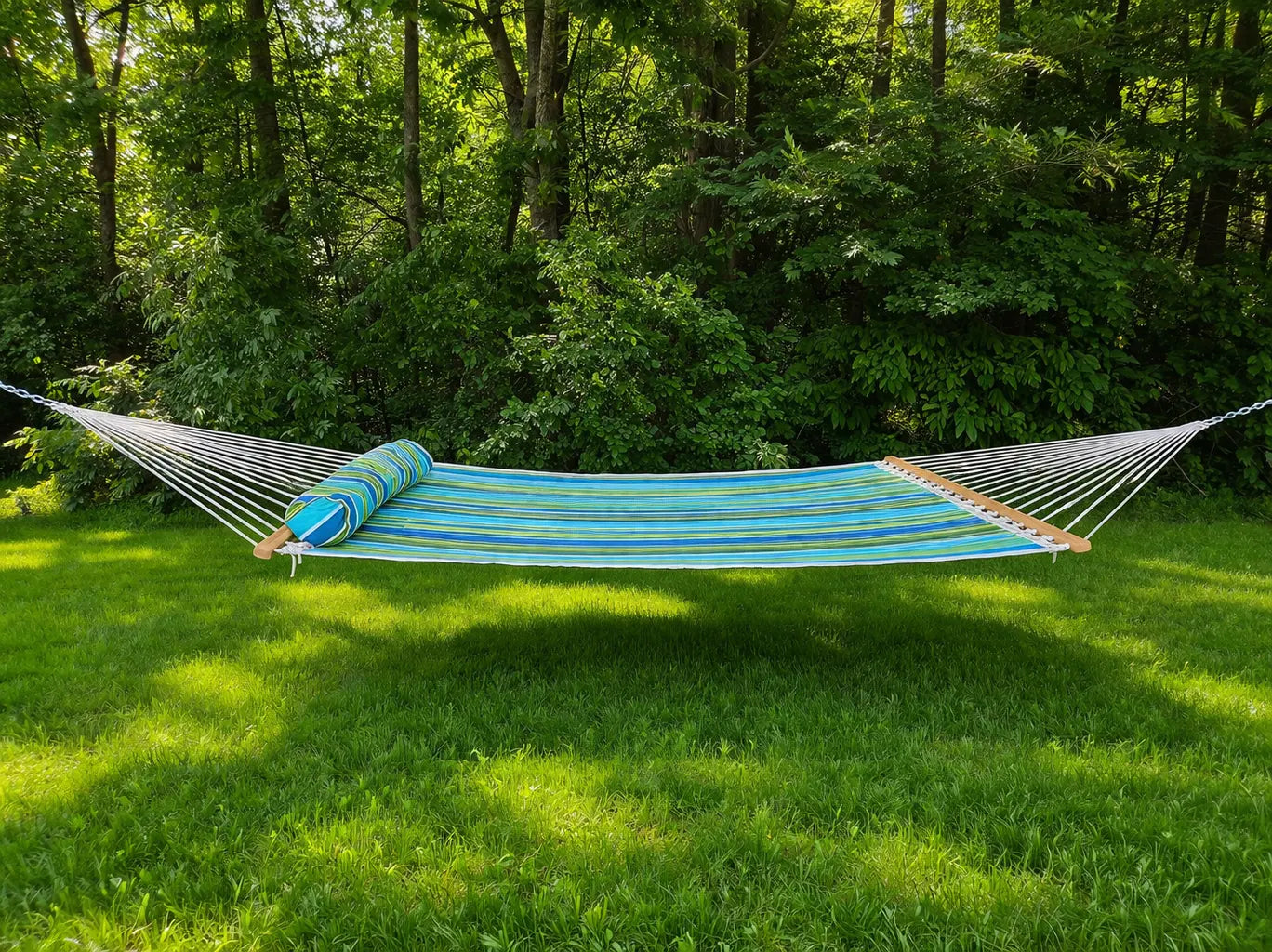 Blue and green striped hammock on grass with trees in the background  QHD-CAROLINA