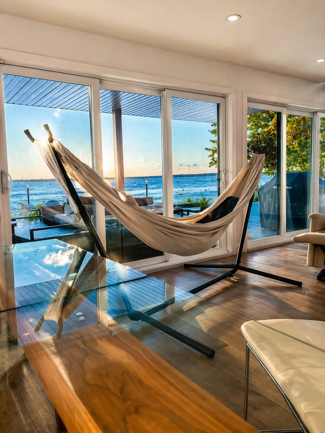 Hammock in a modern living room with large windows overlooking a scenic view.